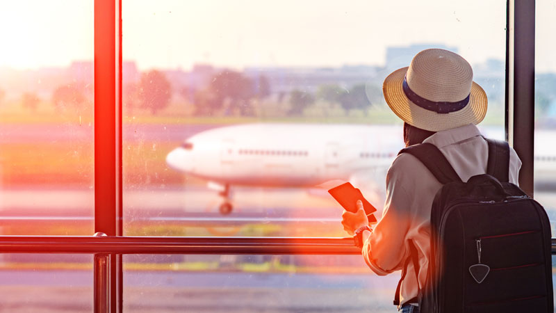 Student looking out window near airport terminal