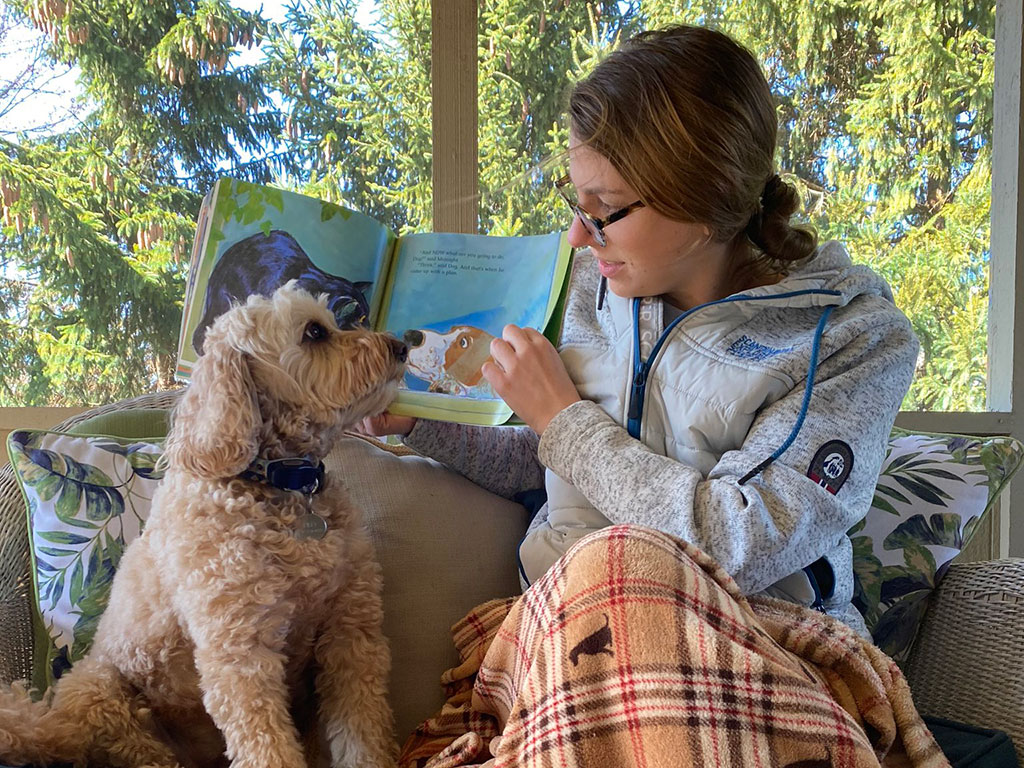 Molly Cason with a book and her dog